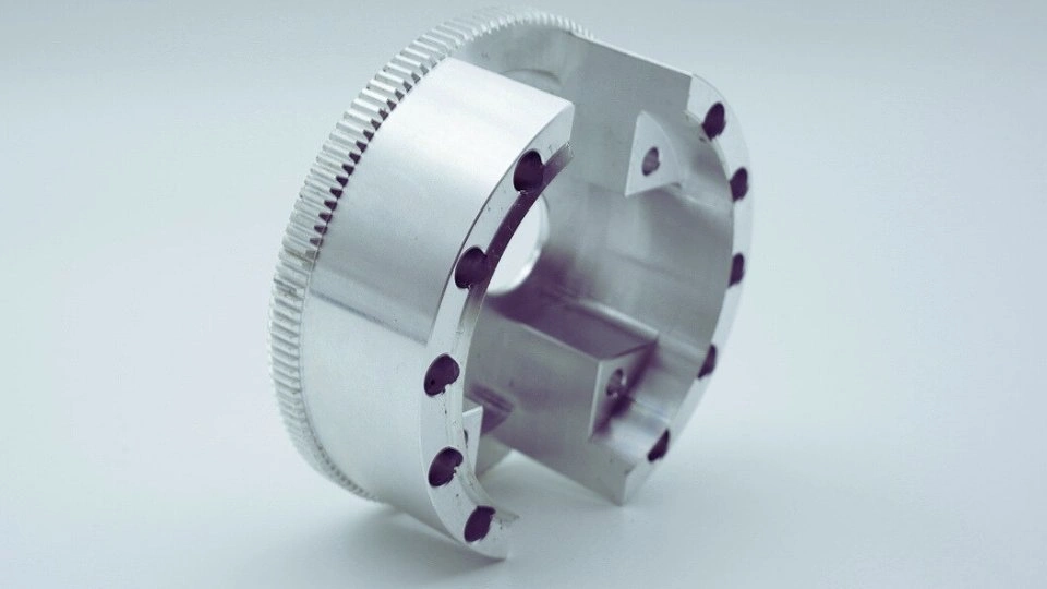 The image shows a precision-machined aerospace part, highlighting its intricate details.