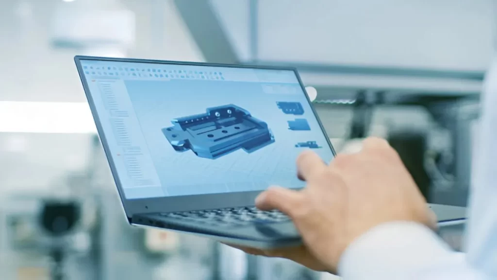 A Design engineer working on a 3D model designing displayed on a laptop screen.