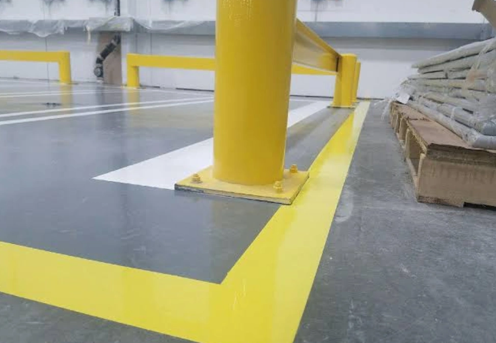 Epoxy-coated warehouse floor with yellow safety line markings 