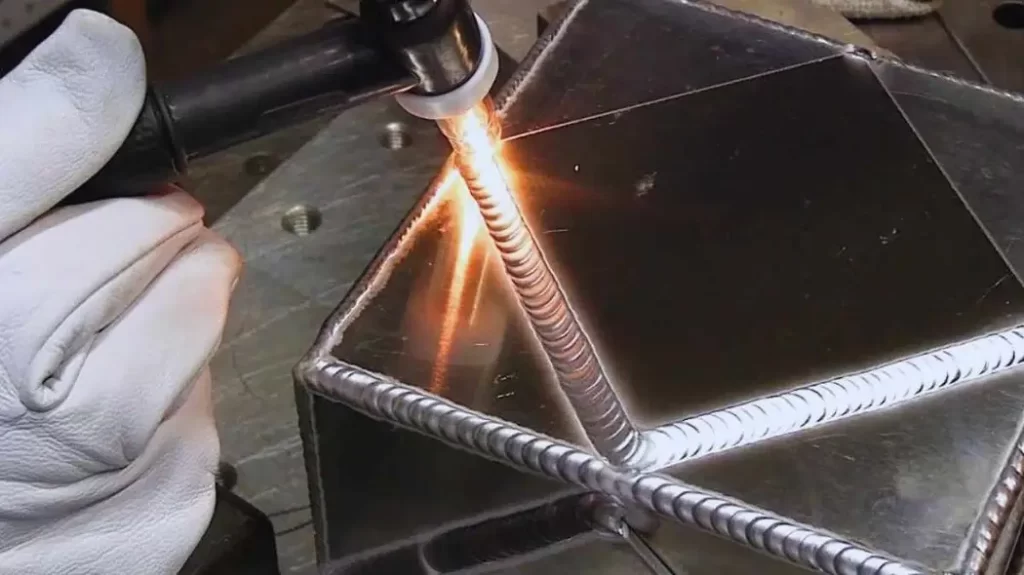 A person skillfully adds detail to an aluminum weld. It shows the art of welding.