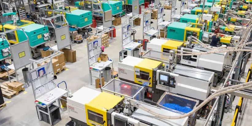 Industrial injection molding factory floor with several automated molding machines in operation