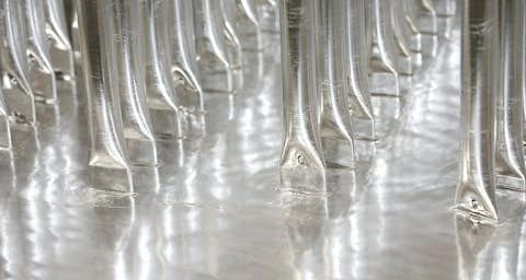 Freshly galvanized steel parts hanging bright silver on a jig straight out of the zinc bath