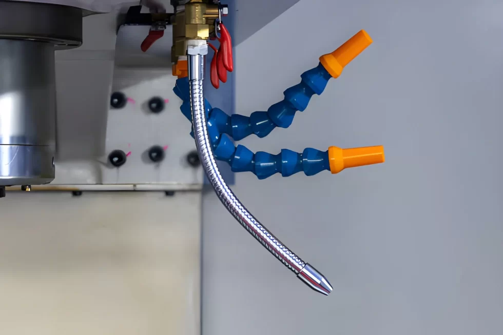 The image shows a CNC machine with an adjustable coolant nozzle.