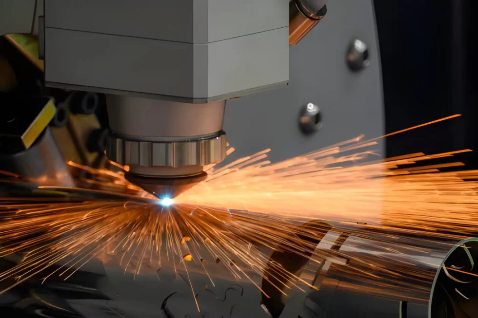 A laser cutting machine precisely cuts a stainless steel pipe, producing clean and accurate holes.