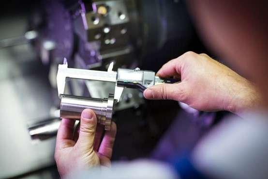 Inspection of parts using vernier calipers in a CNC workshop