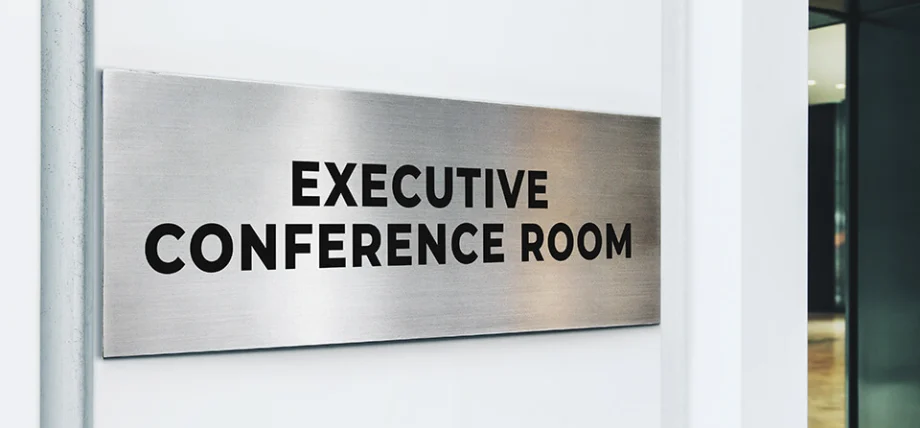 Gray metallic office sign with brushed lines and text “Executive Conference Room”