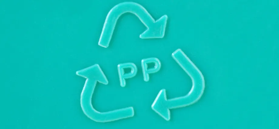 A close-up of a teal-colored plastic surface featuring the embossed 