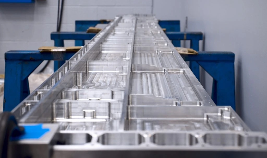 A large aluminum machined part on display.