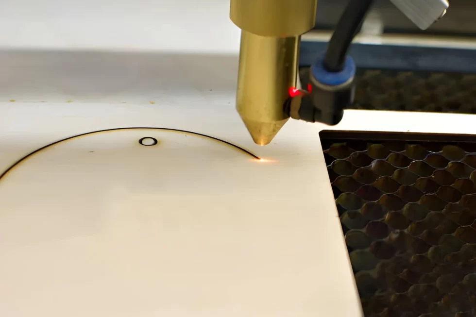 A close-up image of a laser engraver, laser burning on wood.