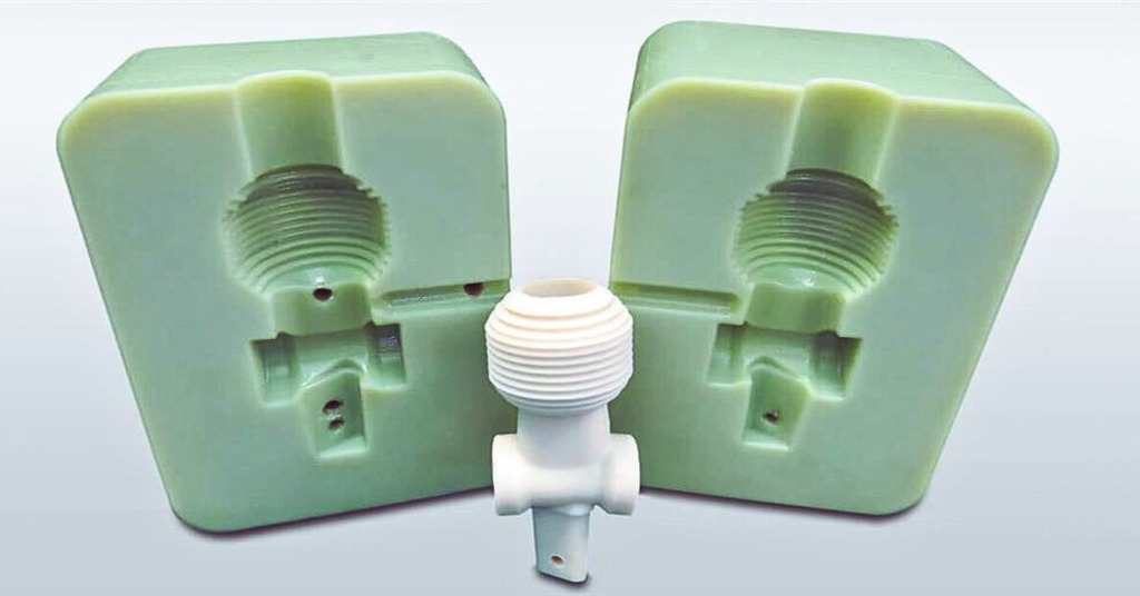 Two-part silicone mold used for rapid prototyping (left and right) with a cast plastic component in the center, showing internal thread features and fine detail replication from the mold cavity.
