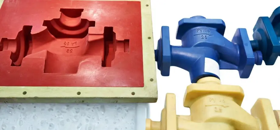 Red plastic mold with injection molded parts in blue and yellow