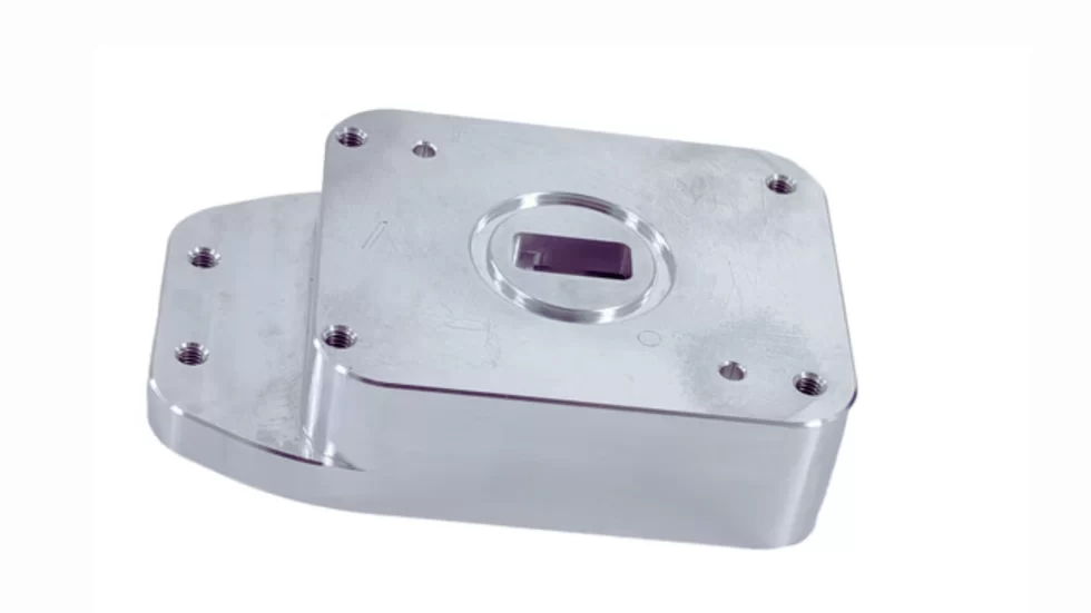 CNC-machined 6061 aluminum component showing drilled holes and milled surfaces.