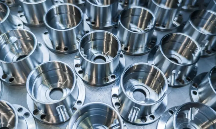 Multiple CNC-machined aluminum parts with threaded holes and precision flanges