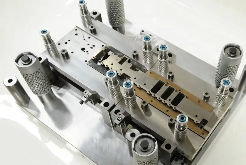 Progressive stamping die with guide pins, punch holders, and stripper plate assembly