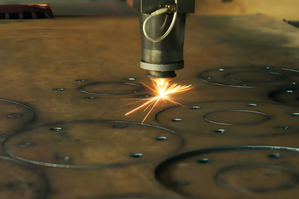 The image depicts a CNC laser machine cutting through a thick metal sheet, producing visible sparks.