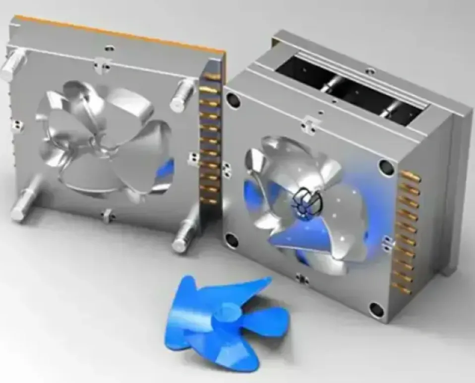 An open injection mold with a blue plastic fan blade functional prototype in the foreground. 