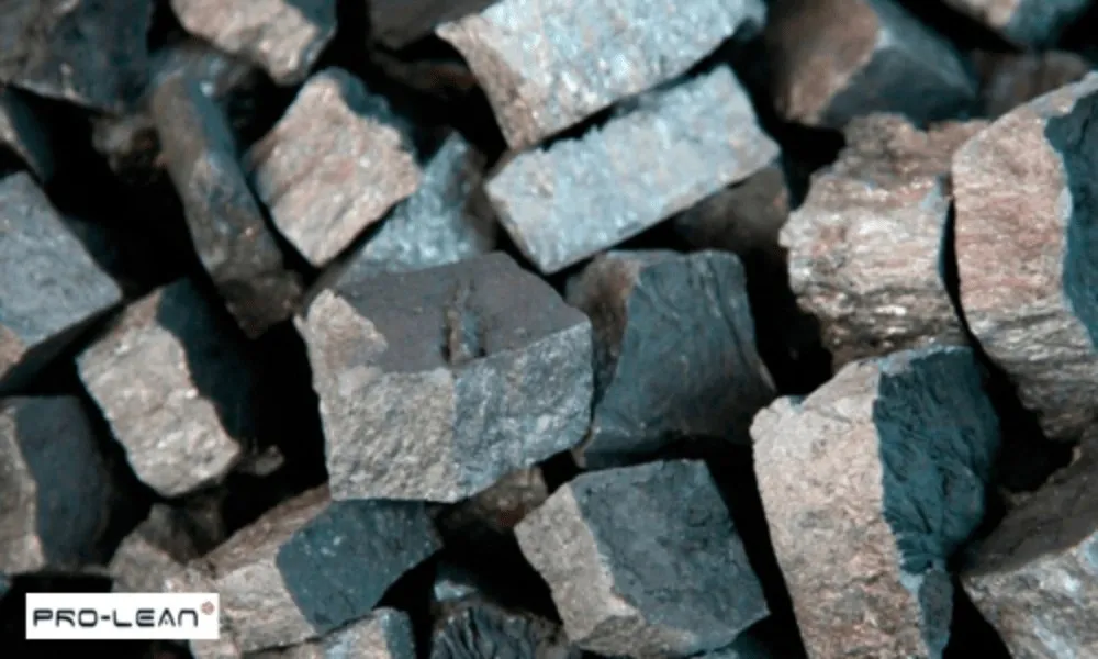Close-up of rough, dark ore fragments, representing raw materials for non-ferrous alloys.
