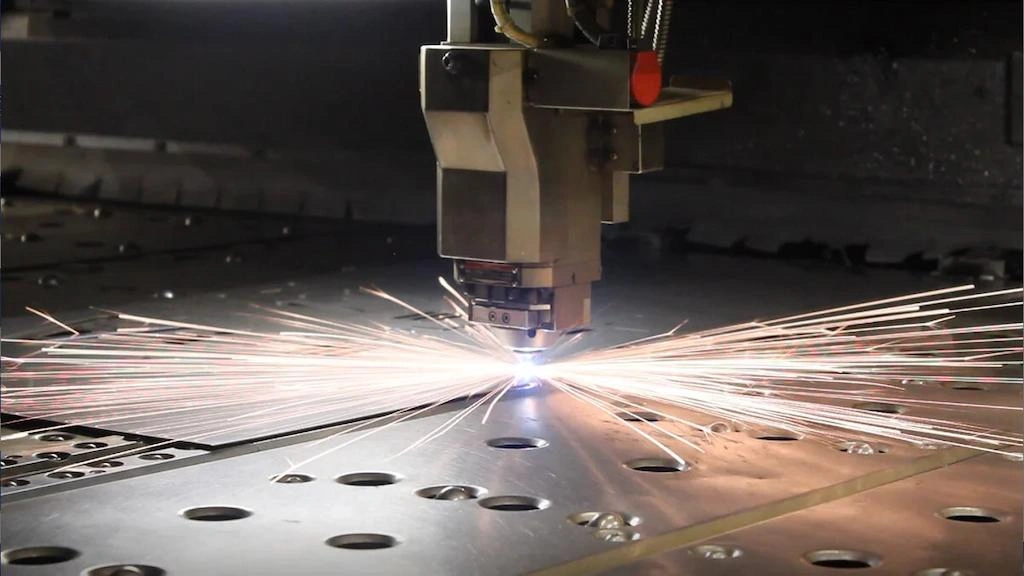An close-up view of laser beam cutting holes on metal sheet