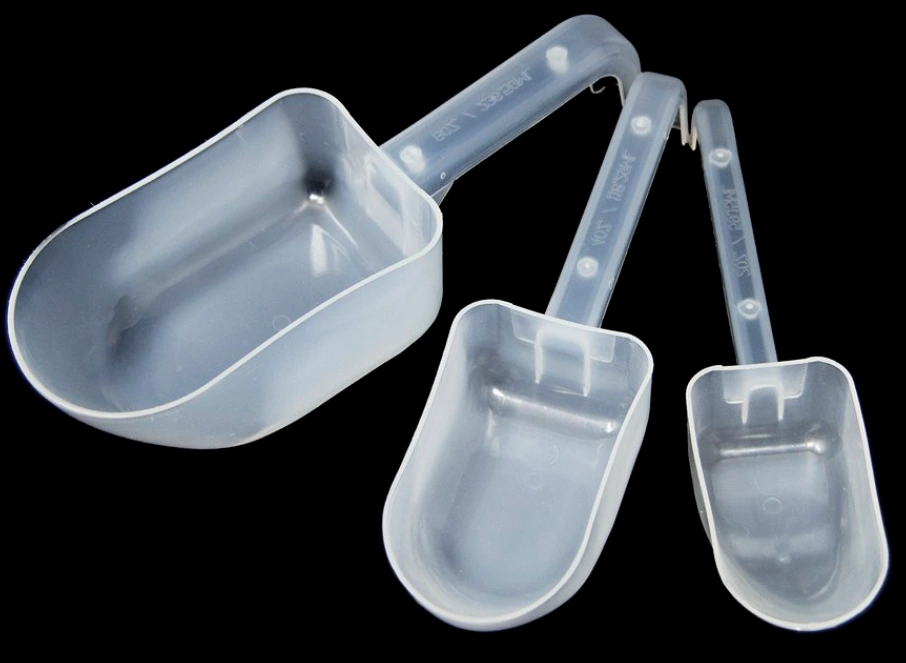 An image of three translucent white polypropylene scoops of varying sizes on a black background