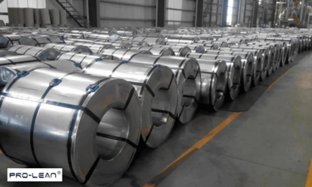Rows of large galvanized steel coils in a warehouse for industrial use.
