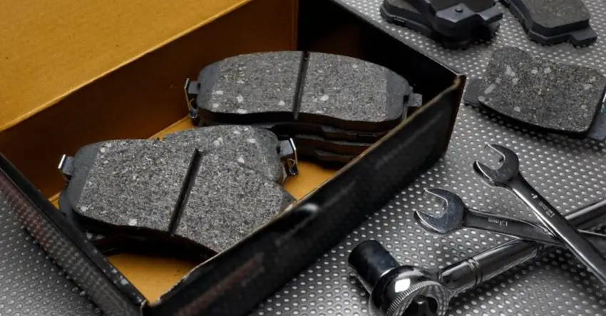CNC-machined ceramic-carbon composite brake pads with metal backing plates and assembly tools