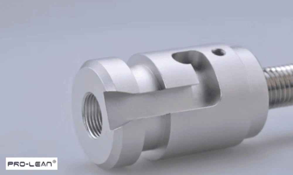 Close-up of a silver metal component with intricate machining details and a threaded end.