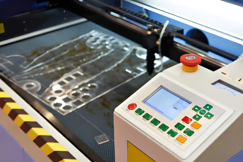 Laser cutting machine with control panel actively cutting a plastic sheet.
