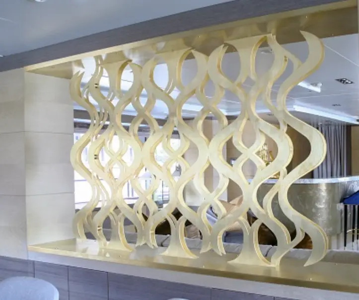 Decorative architectural feature with a flowing wave pattern cut from metal using waterjet technology in a modern interior