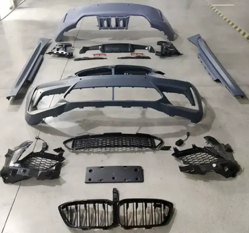 Disassembled polypropylene automotive bumper components and trim parts laid out on the floor