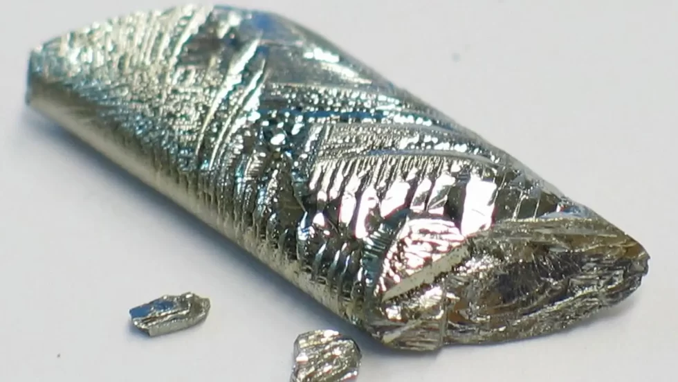  A close-up of a long, metallic, crystalline piece of the element tellurium.